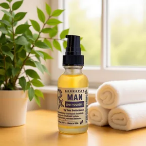 Rockstar Man intimate & body oil on a sunny windowsill beside rolled towels
