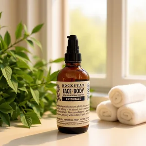 Rockstar Face & Body Entourage on a sunny windowsill beside rolled towels